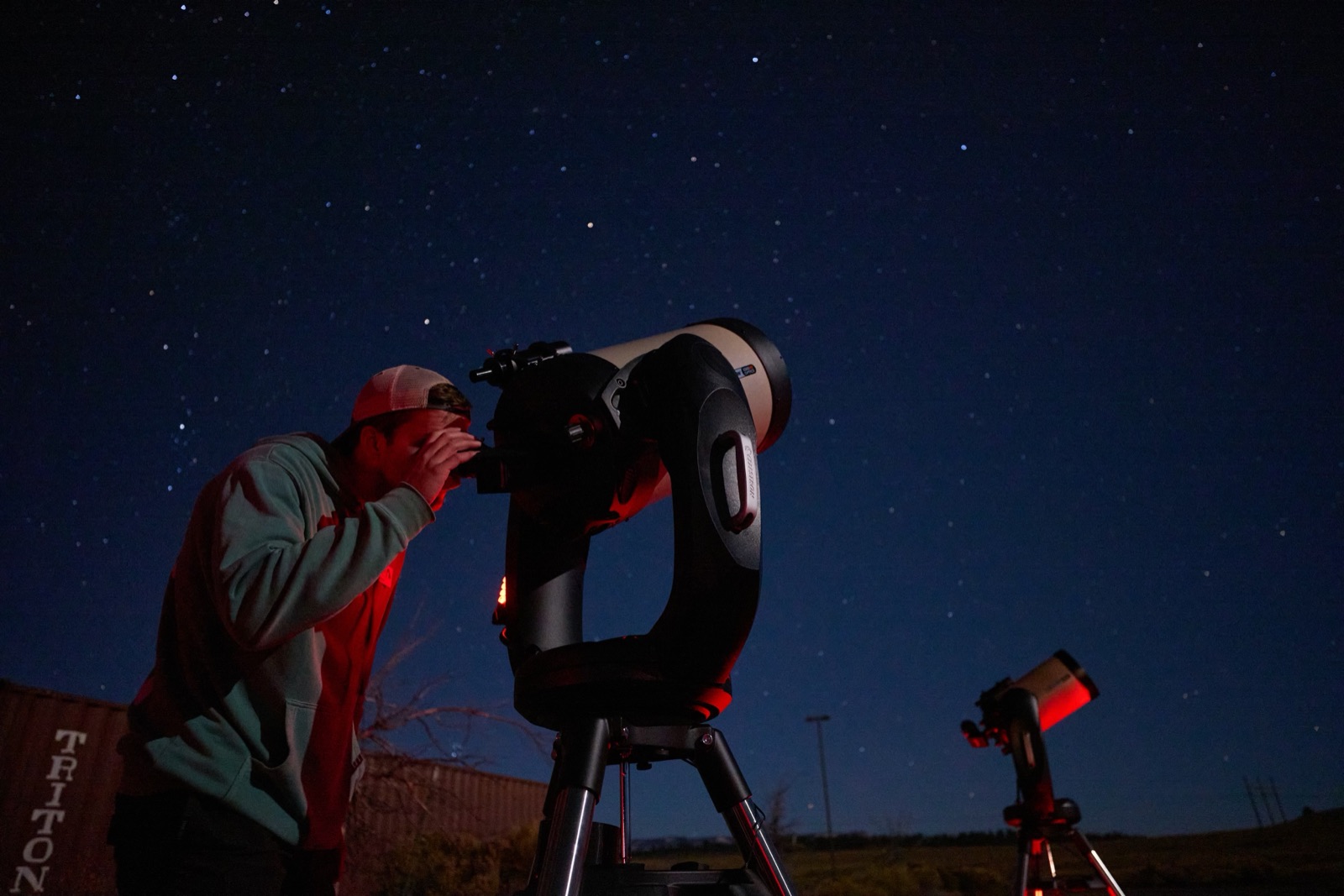 Guest looking through a telescope under a starry night sky near Bryce Canyon